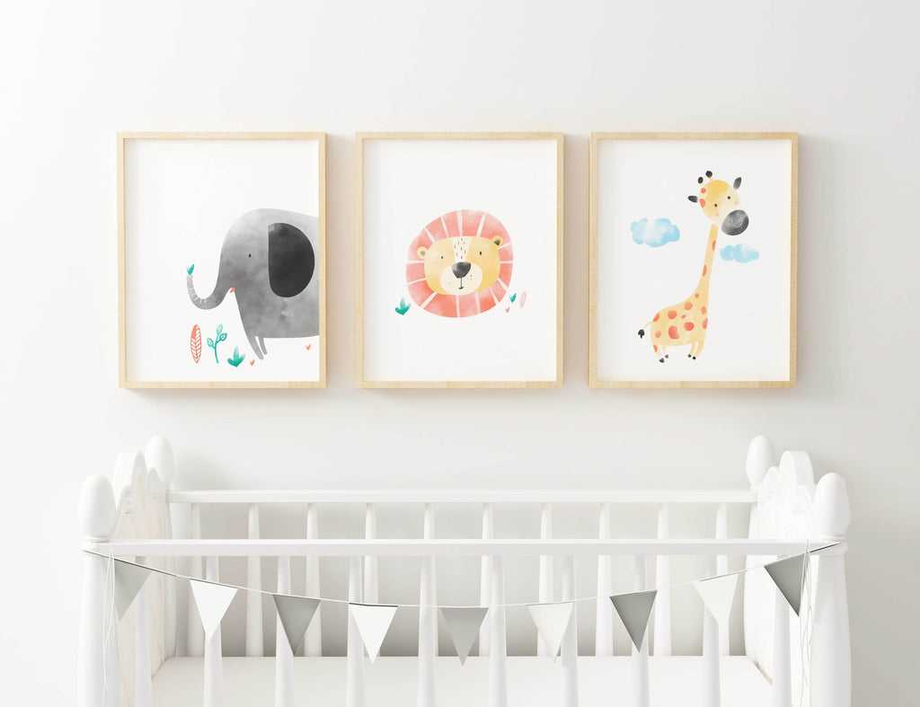 Three framed Wall Funk Children's Safari Watercolour Animal Prints—elephant, lion, giraffe—adorn a crib with silver pennant flags.