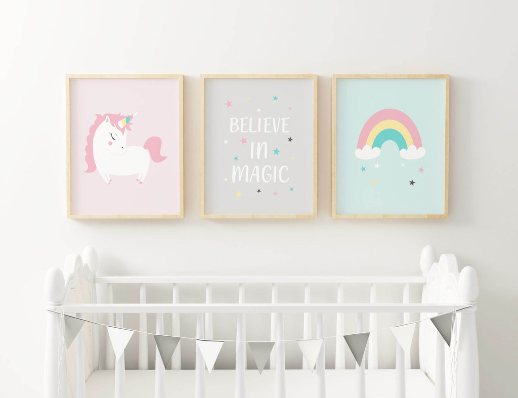 Three Wall Funk NP#37 prints above a white crib feature a unicorn, text, and rainbow. A silver bunting decorates the crib.