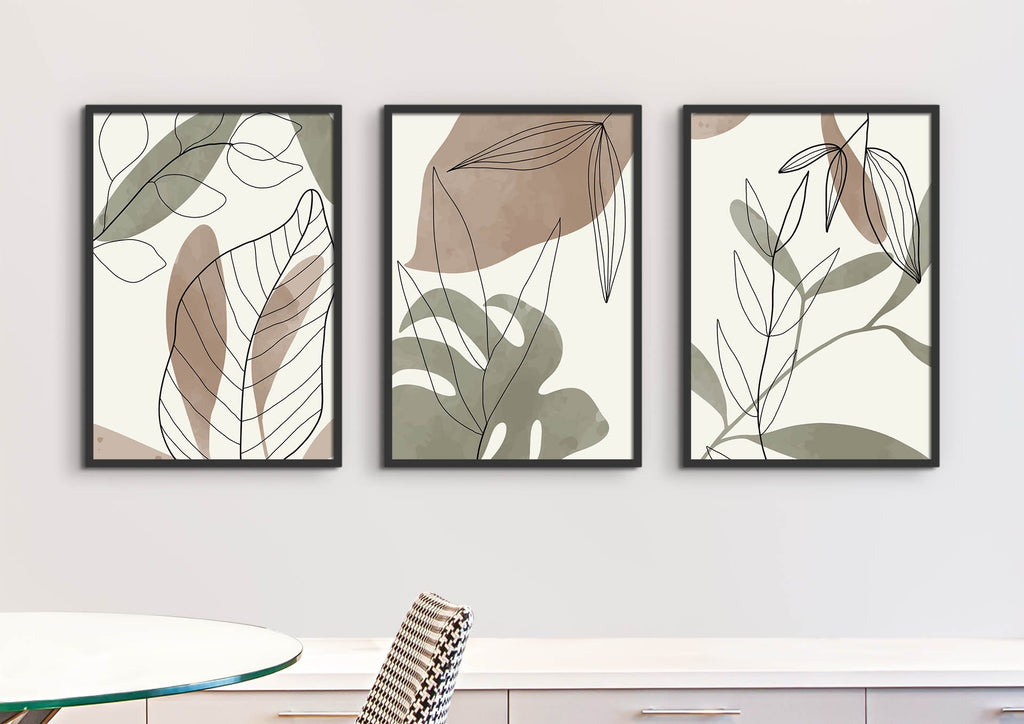 Wall Funk's Floral Abstract Wall Art features three framed prints with beige and green hues on a white wall above a table and chair.