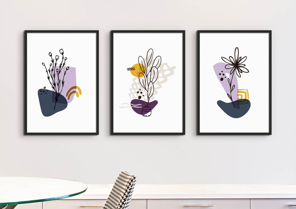 Lilac Boho Flowers by Wall Funk; set of three floral abstract prints in black frames, shown above a white table and modern chair. Custom sizes.