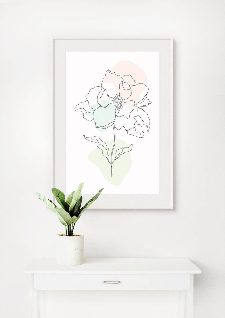 Floral Abstract Wall Art by Wall Funk, framed on pastel card, hanging above a table with a green plant in a white pot.