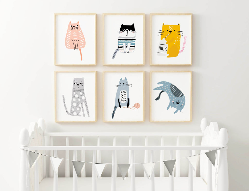 Six Wall Funk cat prints adorn the wall above a white crib with silver bunting, creating a charming nursery look.