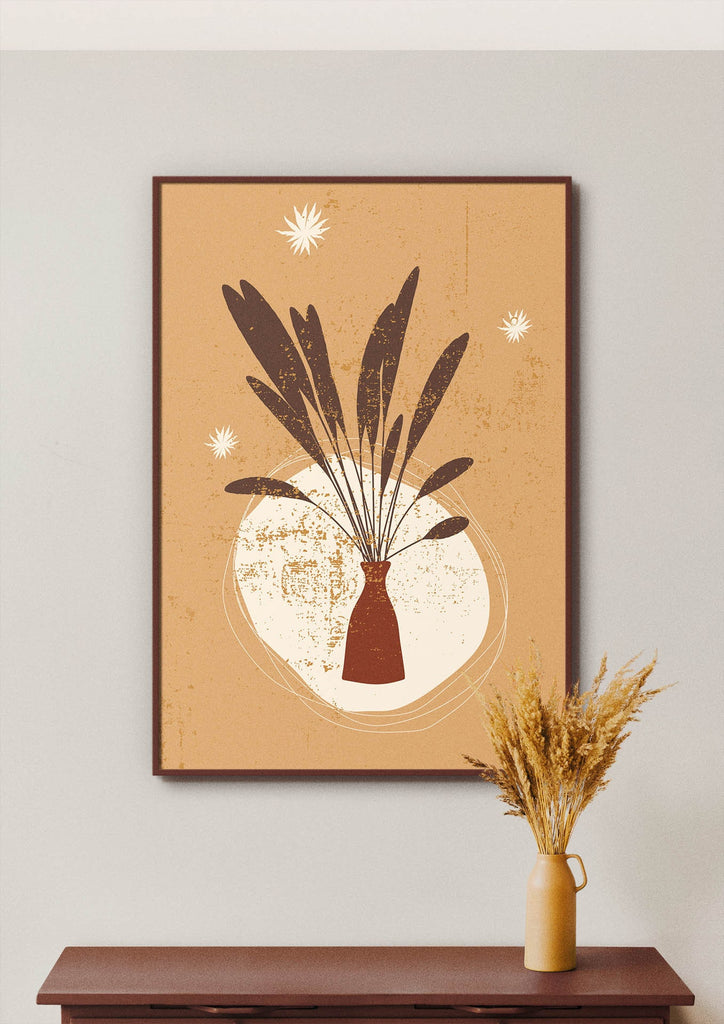 Floral Abstract Wall Art by Wall Funk: Brown leaves in a vase on beige wall, above table with floral prints and dried grass.