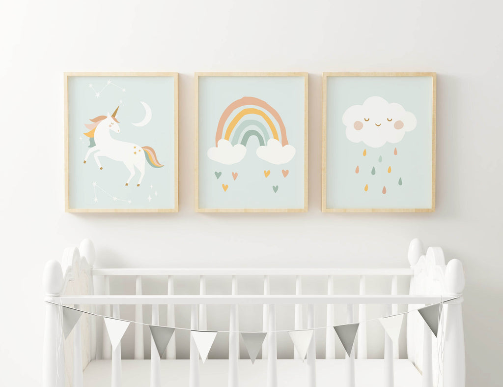 The Wall Funk NP#46 nursery prints featuring a unicorn, rainbow, and raindrop cloud hang above the crib with a silver triangle garland.