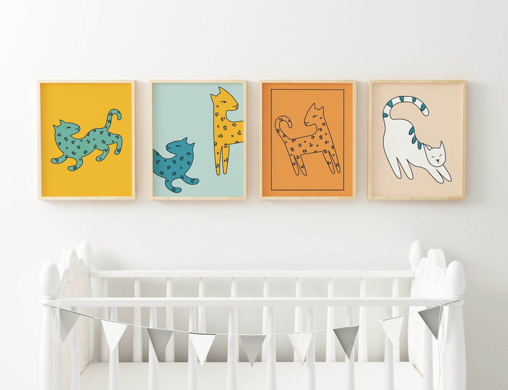 Four Wall Funk colorful cat prints are framed above a white crib with a gray and white triangular garland.