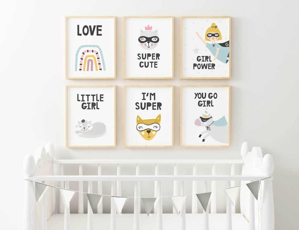 A white crib with bunting is in front of 6 Wall Funk nursery prints featuring playful animals and empowering messages for girls.