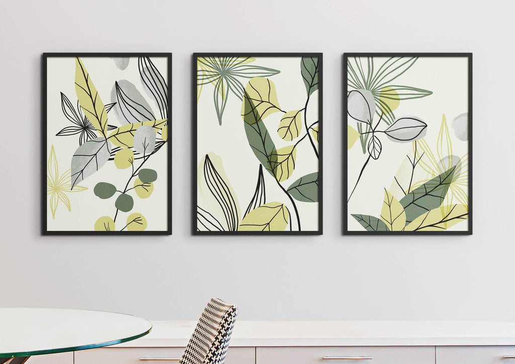 Wall Funk's Watercolour Green Leaves Floral Abstract Prints adorn a white wall above a table with a striped chair.