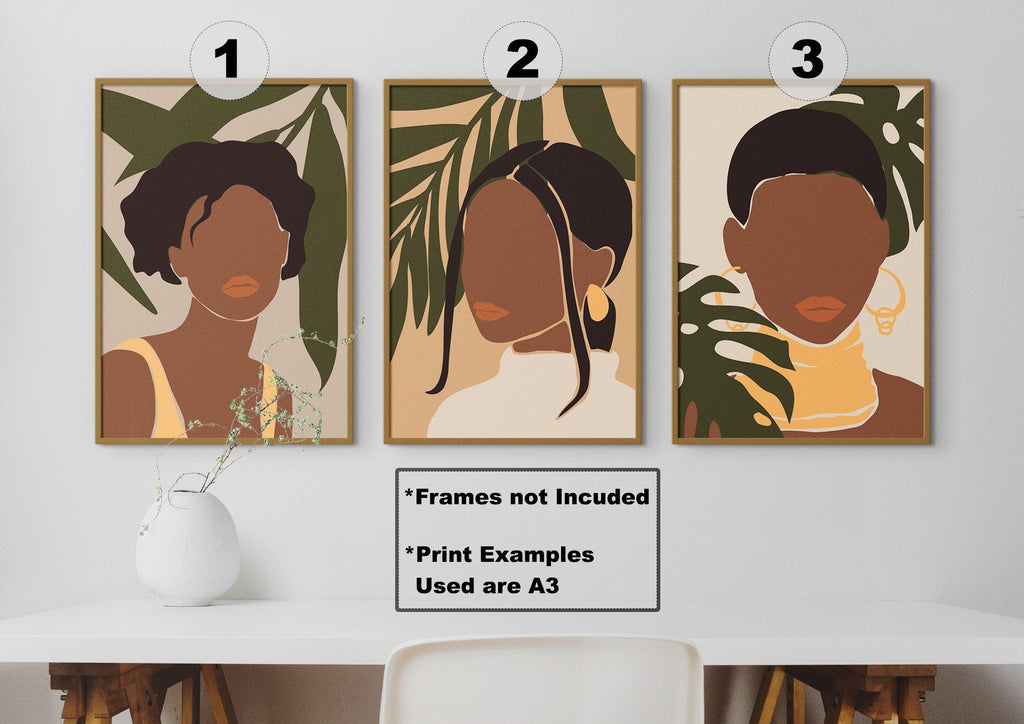 Wall Funk's "Beautiful African Women" abstract portraits with bold hues adorn a white wall above a table with a vase and dried flowers.