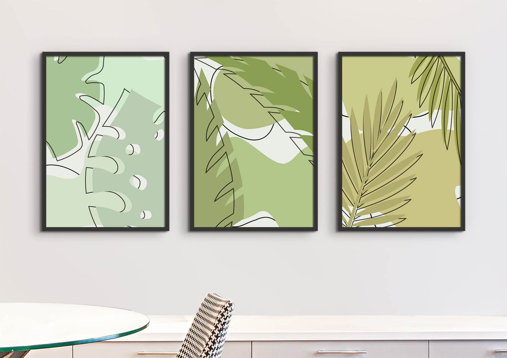 Layered Green Leaves Floral Wall Art Prints by Wall Funk: 3 framed prints in green/beige above a white table and patterned chair, custom sizes.