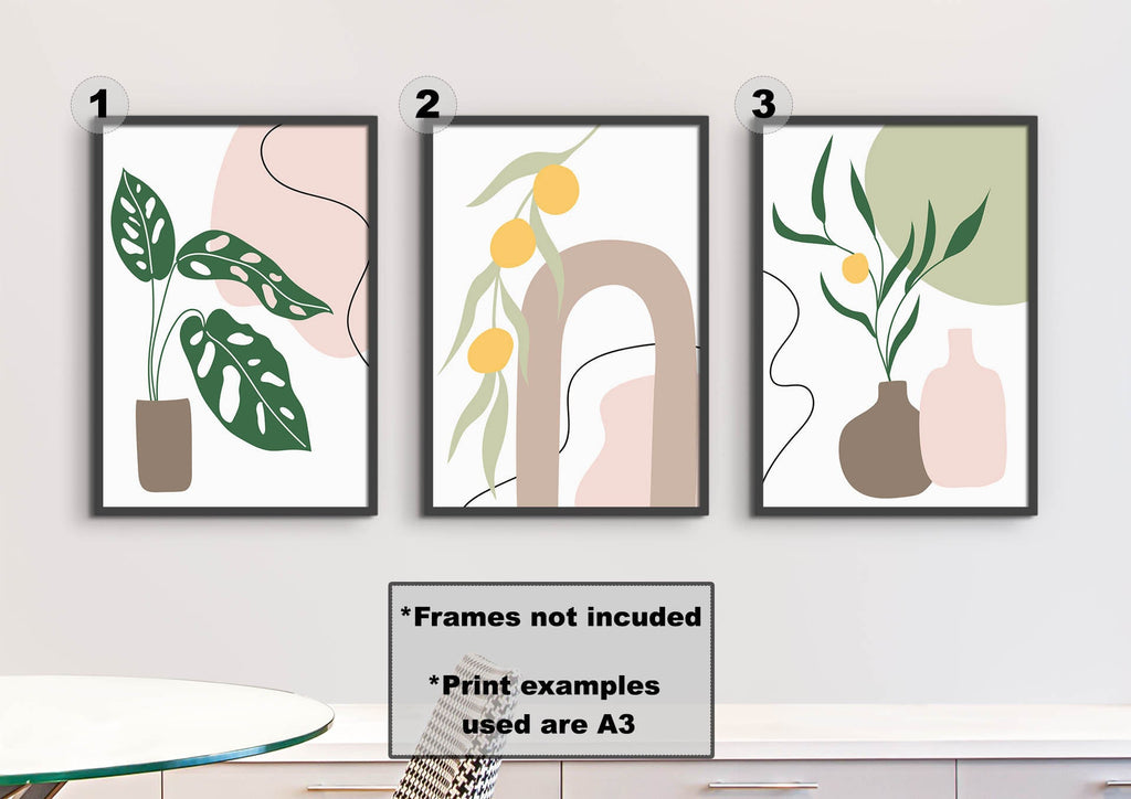 Three Floral Abstract Wall Art prints by Wall Funk with leaves and vases adorn the wall above a table.