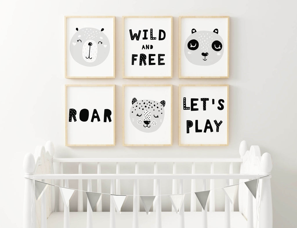 A Wall Funk nursery wall with six Charming Boho prints: animal faces, "Wild and Free," "Roar," and "Let's Play." White crib with bunting.