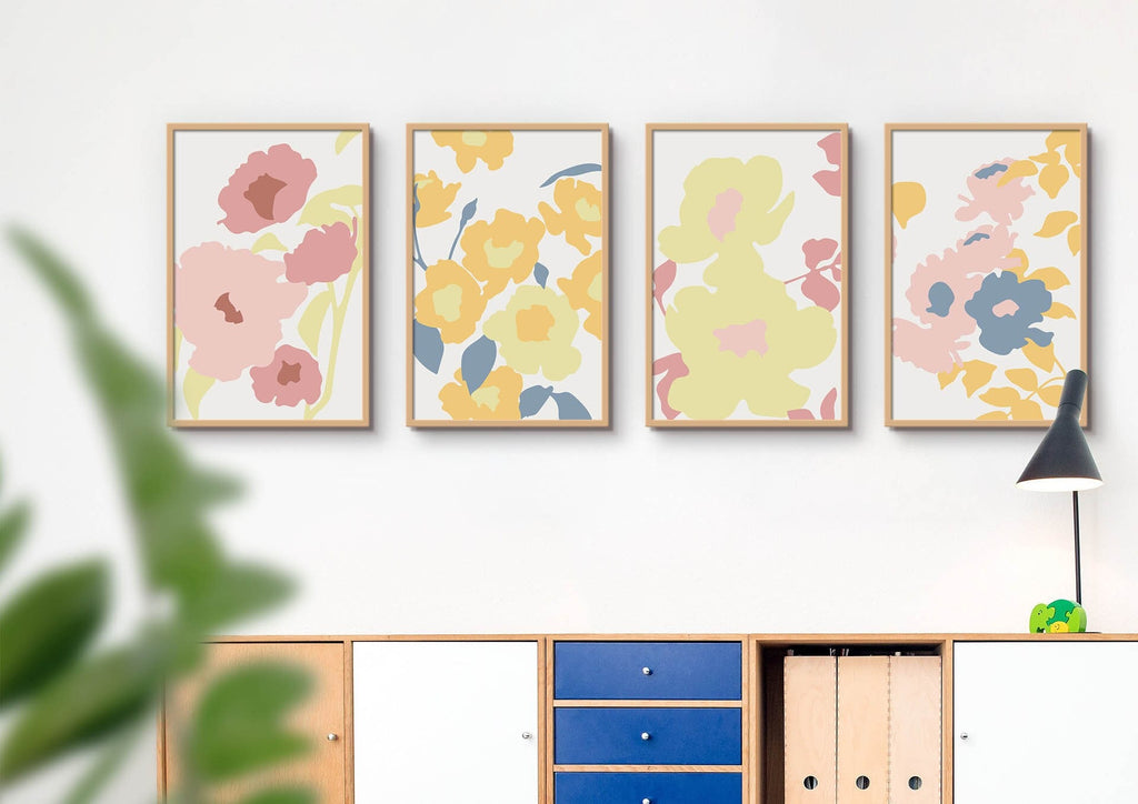 Four Wall Funk's Floral Abstract prints adorn the wall above a modern cabinet, with a potted plant and black lamp beside them.