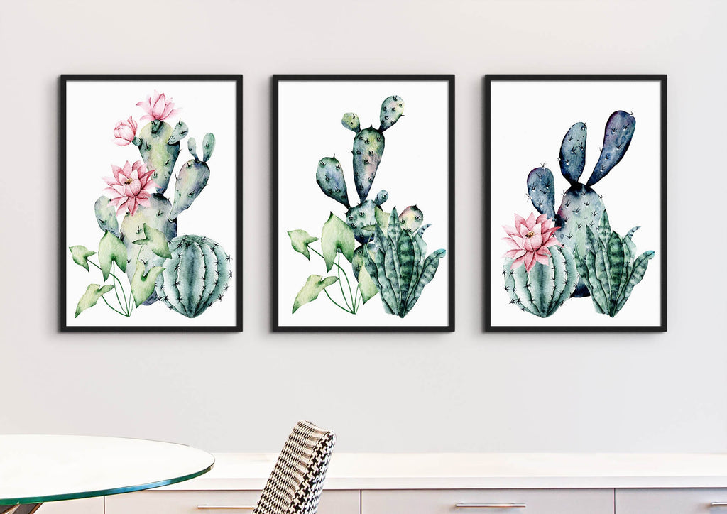 Floral Abstract Wall Art by Wall Funk: three cactus prints with pink flowers adorn a white wall above a table and chair.