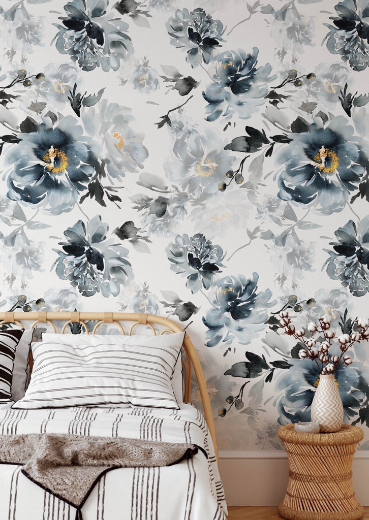 a bed sitting next to a wall covered in floral wallpaper